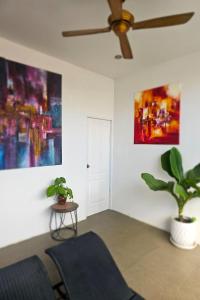 a living room with a ceiling fan and a plant at One World One Home Naiharn Hotel in Rawai Beach