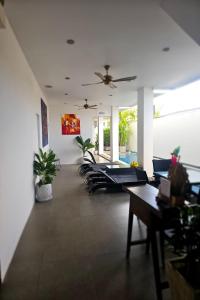 a room with chairs and tables and a ceiling fan at One World One Home Naiharn Hotel in Rawai Beach