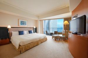 pokój hotelowy z łóżkiem i telewizorem z płaskim ekranem w obiekcie The Yokohama Bay Hotel Tokyu w mieście Jokohama