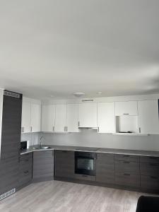 a kitchen with white cabinets and stainless steel appliances at Mosjøen Romutleie EGEDESGATE 49 in Mosjøen