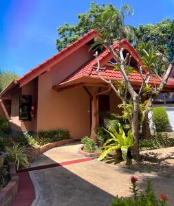 une maison avec un toit rouge et une passerelle dans l'établissement The Pace Phuket Boutique Resort, à Rawai Beach