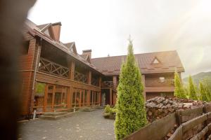 a building with a pine tree in front of it at Chalet Filvarok in Slavske