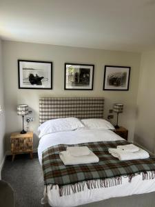 a bedroom with a bed with three pictures on the wall at The Shore in Kirkwall