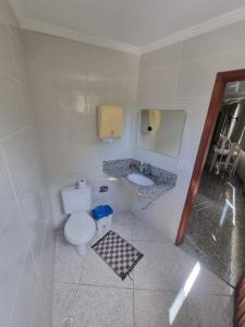 a small bathroom with a toilet and a sink at Pousada e Hospedaria Regina in Cachoeiro de Itapemirim