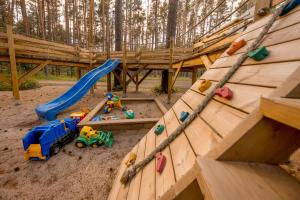 un parque infantil con equipo de juegos de madera y un tobogán en Villa MARIKA plus en Alajõe