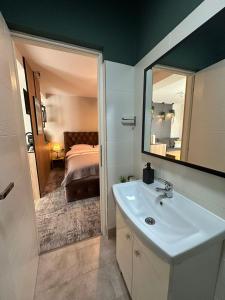 a bathroom with a sink and a mirror and a bed at Luxury Studio in Iaşi