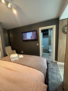 a bedroom with a bed with a tv on the wall at Luxury Studio in Iaşi