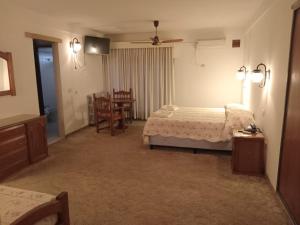 una camera con letto, tavolo e sedie di Gran Hotel Las Lajas a Villa Carlos Paz