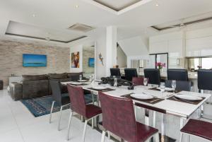 uma sala de jantar com uma mesa longa e cadeiras em Villa Oceane em Thong Son Beach