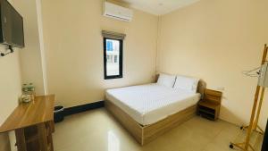 ein kleines Schlafzimmer mit einem Bett und einem Fenster in der Unterkunft VIENTIANE BB Hostel in Vientiane