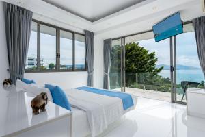 um quarto com uma cama grande e uma janela grande em Villa Oceane em Thong Son Beach