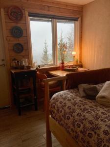 a bedroom with a bed and a table and a window at Fritt! Bed&Breakfast in Seljord