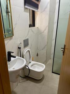 y baño con aseo blanco y lavamanos. en Kawruky Hotel Benin en Benin City