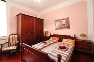 a bedroom with two beds and a chair at Apartment Frketić with roof terrace and panoramic sea view in Opatija