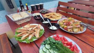 a wooden table with plates of food on it at The Friends in Kutaisi