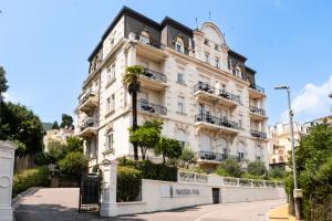 a large white building with balconies on a street at Amadria Park Hotel Agava in Opatija