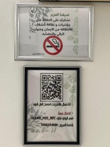 two framed pictures on a wall with a no smoking sign at اطلالة الريان شقة خاصة in Jeddah