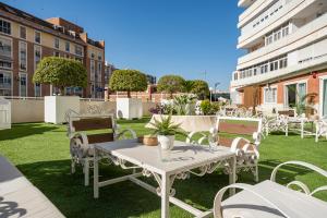 een patio met een tafel en stoelen op het gras bij Hotel Las Américas in Málaga