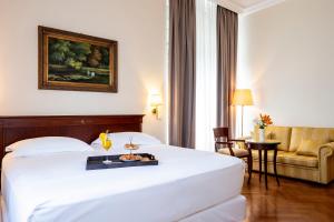 a hotel room with a bed with a tray of food on it at Amadria Park Hotel Agava in Opatija