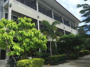 un edificio bianco con alberi di fronte di Baan Suan Ta Hotel a Ko Tao