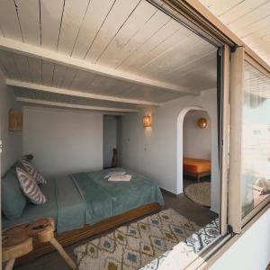 1 dormitorio con cama y ventana grande en Surf HouseMaroc en Esauira