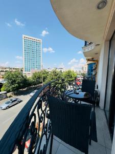 un balcone con tavoli e sedie in un edificio di Hotel Real a Pristina