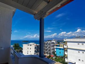 een balkon met uitzicht op de oceaan en gebouwen bij Dine Apartments in Ksamil