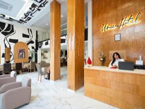 a woman sitting at a counter in a hotel lobby at Unico Hotel Maarif in Casablanca