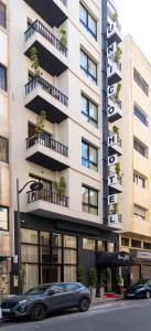 a building with a car parked in front of it at Unico Hotel Maarif in Casablanca