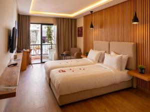 a hotel room with a large bed and a television at Unico Hotel Maarif in Casablanca