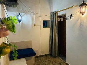 a bathroom with a shower and a blue bench at Le Refuge Djerbien in Houmt Souk