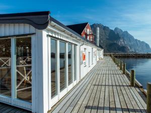 um edifício numa doca ao lado de uma massa de água em Fast Hotel Henningsvær em Henningsvær