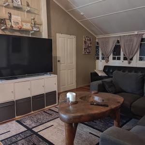 Sala de estar con TV grande y mesa de centro en La Maison Blanche en Atherton