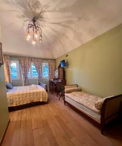 a bedroom with two beds and a chandelier at Hotel Le Ponteil in Antibes