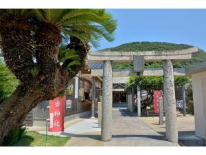 una pasarela con una palmera frente a un edificio en Asuka Hotel - Vacation STAY 59970v, en Karatsu