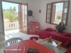 a living room with two beds and a chair at La rose 1 in Mezraya