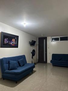 un soggiorno con 2 divani blu e una TV di Hotel Olam Confort a Villavicencio