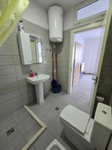 a bathroom with a toilet and a sink at Roxhensi 2 in Shëngjin