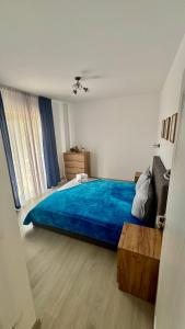 um quarto com uma cama com um cobertor azul em Adam Home Ap em Falticeni