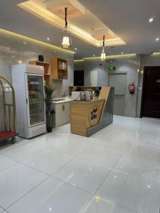 a large kitchen with a refrigerator and a counter at درة الشرق للشقق المخدومة in Medina