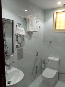 a bathroom with a toilet and a sink and a shower at درة الشرق للشقق المخدومة in Medina