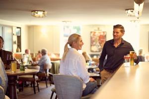 un homme et une femme assis au bar d'un restaurant dans l'établissement The Leddie, à Aberlady