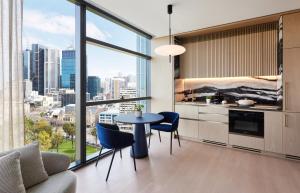 cocina con mesa y sillas y vistas a la ciudad en Lanson Place Parliament Gardens en Melbourne