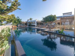 ein Pool mit Bäumen und ein Gebäude in der Unterkunft Asty Mykonos Hotel & Spa - World of One Hotel Group in Mykonos Stadt