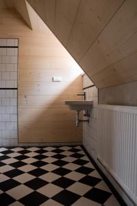 a bathroom with a sink and a black and white checkered floor at Apartmán 121 in Nové Město na Moravě