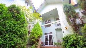 una vista exterior de una casa blanca con plantas en Bellbird en Aso