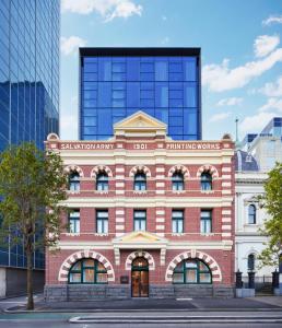 un edificio de ladrillo rojo frente a un edificio alto en Lanson Place Parliament Gardens en Melbourne