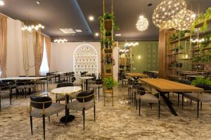 a restaurant with tables and chairs and potted plants at Sentir Hotel in Gura Humorului