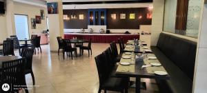 un comedor con mesas y sillas en un restaurante en The Altruist Business Hotel Kharadi, en Pune