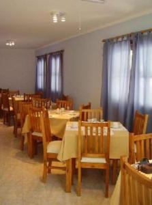 - une salle à manger avec des tables, des chaises et des rideaux dans l'établissement Muras Apart Hotel, à Mendoza